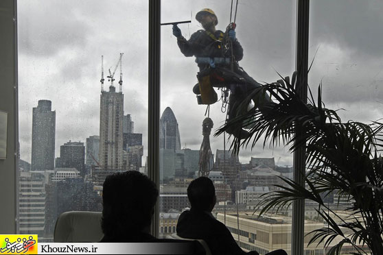 SQUEAKY CLEAN: People watched as a window washer worked outside the 14th floor at the Shard in London on Wednesday. (Luke MacGregor/Reuters)