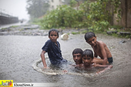 SWIRLING: Boys played inside a drain during a downpour in Mumbai Thursday. Monsoon rainfall this season has been about half of normal levels, raising concerns for farmers. (Ahmad Masood/Reuters)
